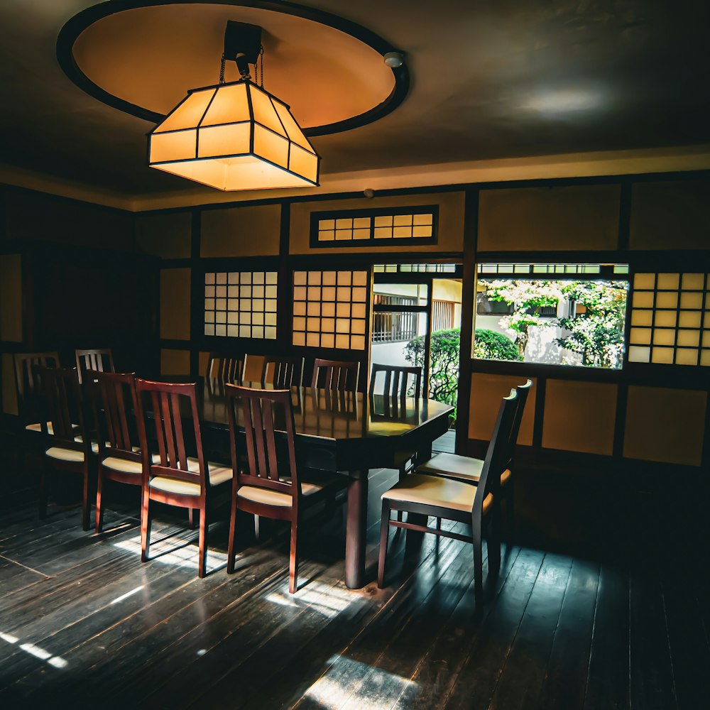 A quiet private dining room with a long wooden table, a paper lantern and shoji windows
